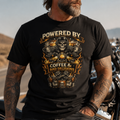 Man wearing a black t-shirt with a graphic design and text, standing next to a motorcycle.