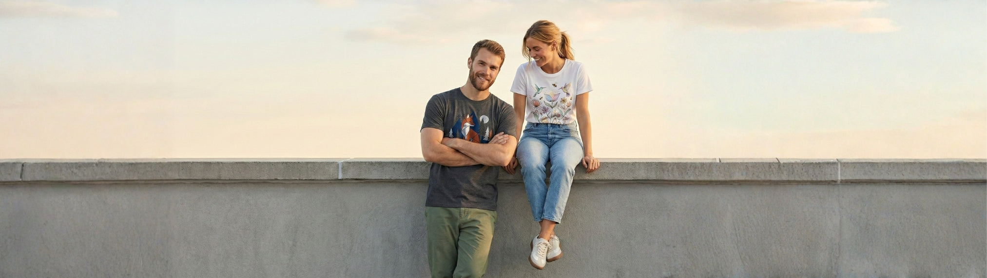 Two people sitting on a ledge with a plain background